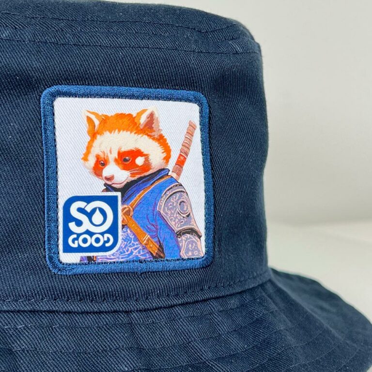 Zoom sur l’écusson SO GOOD représentant un panda roux sur un bob bleu marine.