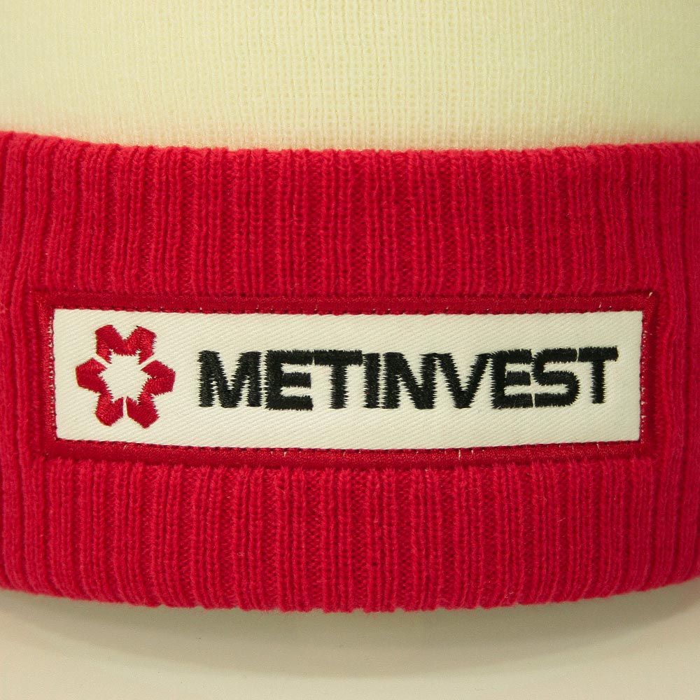 Zoom sur l’écusson brodé METINVEST cousu sur le revers du bonnet rouge.