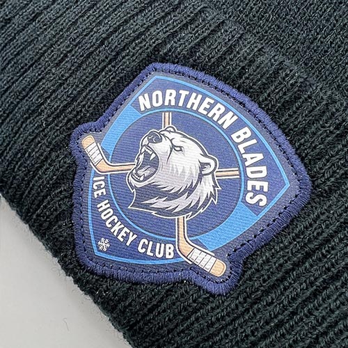 Écusson brodé Northern Blades Ice Hockey Club cousu sur un bonnet de hockey noir.