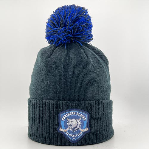 Bonnet de hockey noir avec pompon bleu et écusson brodé sur le devant