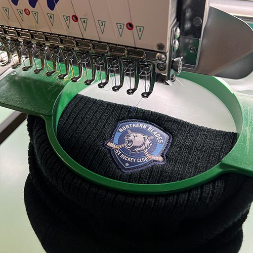 Broderie d’un écusson sur bonnet de hockey réalisée sur machine industrielle
