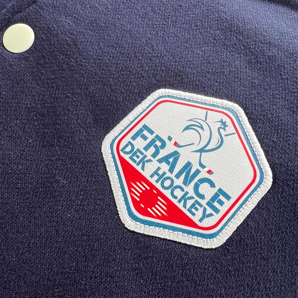 Gros plan sur l’écusson France de Hockey cousu sur un teddy bleu marine