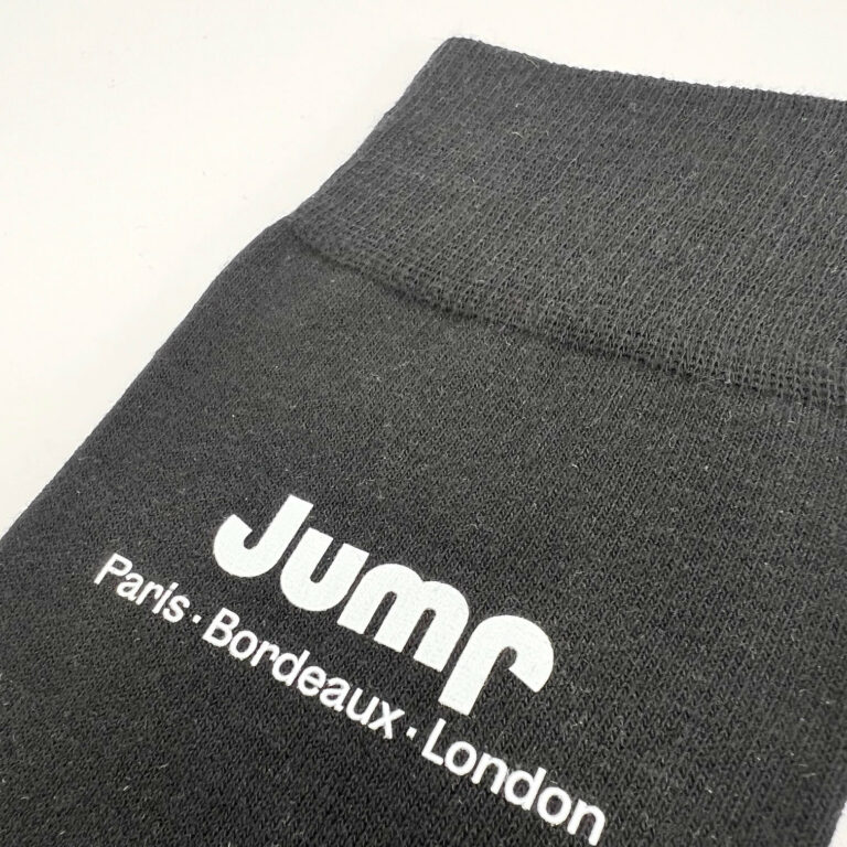 Marquage par impression blanche sur le haut d'une chaussette personnalisée noire pour la marque Jump (Paris, Bordeaux, London). Rendu précis et net du logo sur textile.