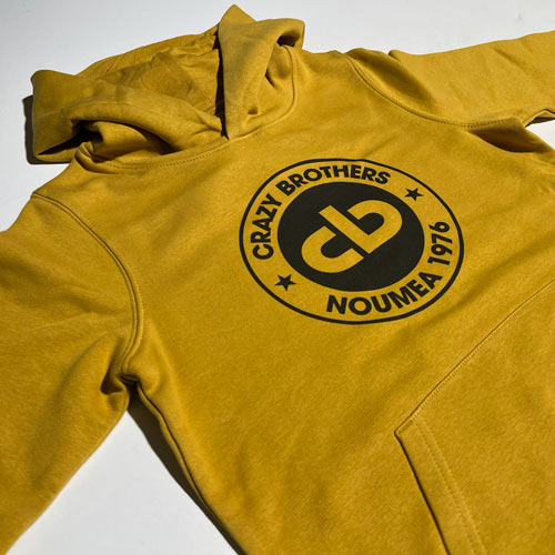 Sweat à capuche jaune moutarde personnalisé avec impression du logo Crazy Brothers Noumea 1976 centré sur la poitrine