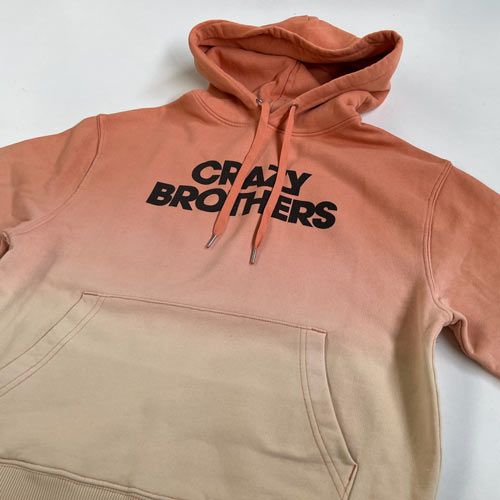 Sweat à capuche tie-dye dégradé saumon terracotta et beige personnalisé avec impression du texte Crazy Brothers en bold noir centré sur la poitrine